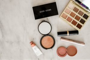 photo of assorted makeup products on gray surface