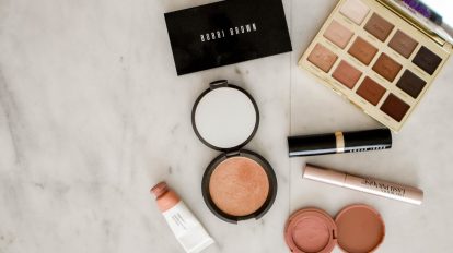 photo of assorted makeup products on gray surface