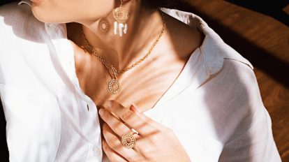 woman in white v neck shirt wearing gold necklace