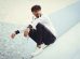 man in white dress shirt and black pants sitting on concrete floor