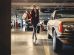 woman carrying shopping paper bags walking towards beige car inside parking lot