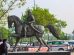 a statue of a man riding a horse in a parking lot