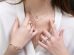 a close up of a person wearing rings and a necklace