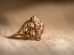 gold diamond studded ring on white textile